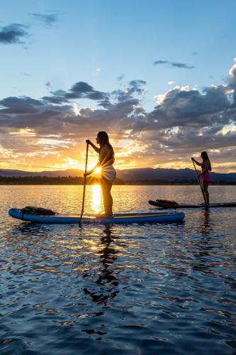 Paddleboarders enjoy a sunset ride on Lake Cascade near the Tamarack Resort Marina.
