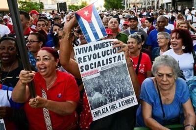 A woman holds a poster reading "Long live our socialist revolution" during celebrations marking victory on the 65th anniversary of the Bay of Pigs invasion