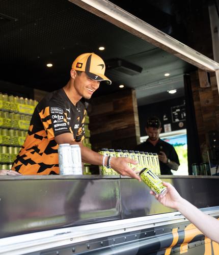 Lando Norris hands out cans of his new Monster Zero Sugar flavor. Photo courtesy of McLaren Racing