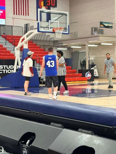 Awesome Home Services volunteer helping at Special Olympics basketball game.