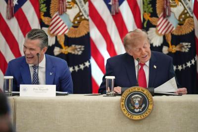 President Donald Trump speaks at a roundtable event at the White House on Oct. 21, 2026, as Defense Secretary Pete Hegseth laughs.