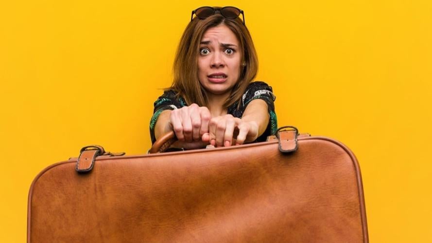 Traveler-woman-holding-leather-bag-scared.jpg