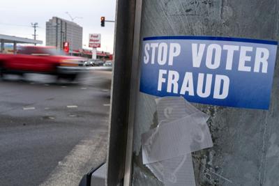 A sticker on a lamppost warns of voter fraud on Nov. 7, 2022, in Anchorage, Alaska.