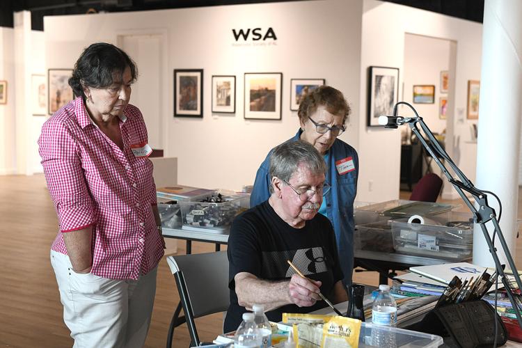 Cliff Williams / TPI Rick Anderson shows two students a watercolor technique during a class as part of the annual member showcase of the Watercolor Society of Alabama that is at the Kelly Fitzpatrick Center for the Arts.