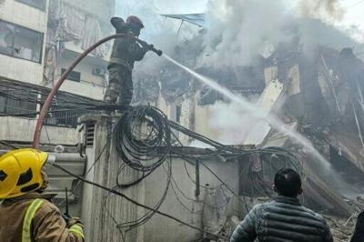 Firefighters at a site of an Israeli air strike in Beirut’s southern suburbs