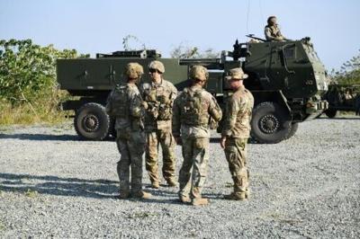 US soldiers stand next to one of their High Mobility Artillery Rocket System (HIMARS) prior to a live fire exercise during a joint exercise between the Philippines and the US at Fort Magsaysay, in the Philippines' Nueva Ecija province north of Manila on...
