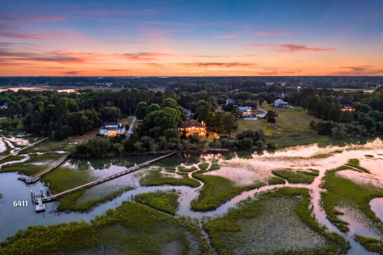 Sunset over Oyster House Creek at 6411 China Back Lane, where 5.2 acres and a private dock create a remarkably private waterfront setting.