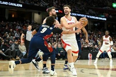 Houston's Alperen Sengun, center right, steps to the basket against Cleveland's Craig Porter Jr., center front, and Dean Wade in a Rockets' NBA victory over the Cavaliers
