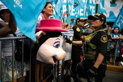 A supporter of Peruvian presidential hopeful Rafael Lopez Aliaga holds a pig mask while waiting for the candidate at a rally