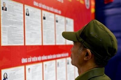 A man views the list of candidates for the upcoming National Assembly and local People's Council elections at a polling station in Hanoi