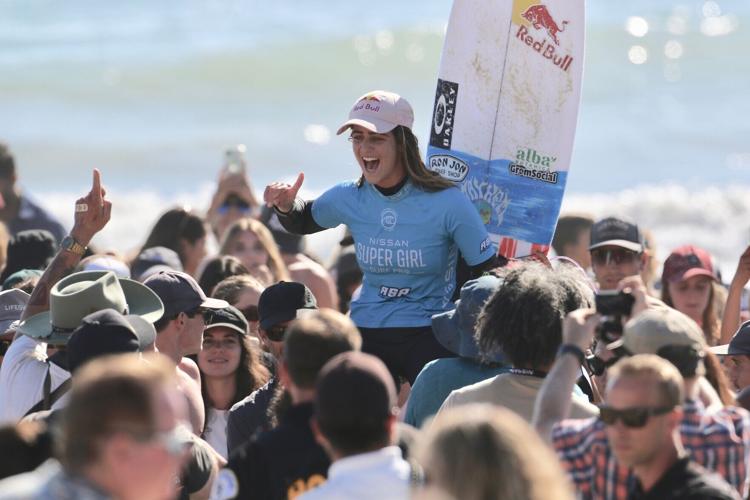 Over 5000 female athletes across 14 sports expected to compete at the inaugural Virginia Beach Super Girl Surf Festival, as did Team USA Olympian Caroline Marks, seen here being lifted up after winning Super Girl Cape at Jax Beach Super Girl Surf Festival.