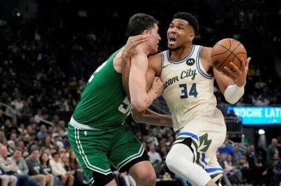 Giannis Antetokounmpo (right) returned from a five-week injury layoff but could not prevent the Milwaukee Bucks suffering a heavy defeat to the Boston Celtics