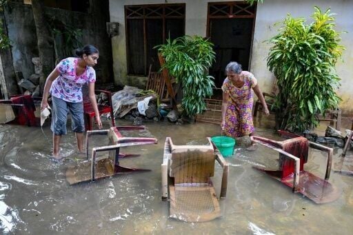 Residents salvage their belongings at an inundated house in Wellampitiya, on the outskirts of Sri Lanka's capital Colombo