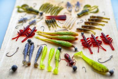 STOCK Colorful silicone fishing baits with plummets on wooden table. V