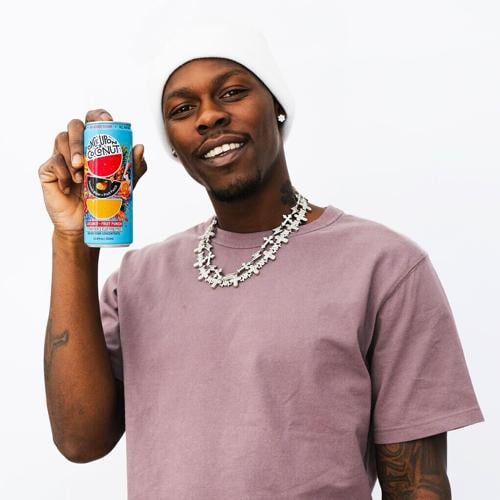 Professional baseball star Jazz Chisholm Jr. holding the Once Upon a Coconut limited-edition Fruit Punch Coconut Water can with no added sugar.