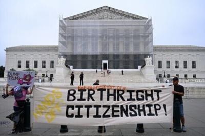 Demonstrators hold a banner outside the US Supreme Court during a June 27, 2025 protest