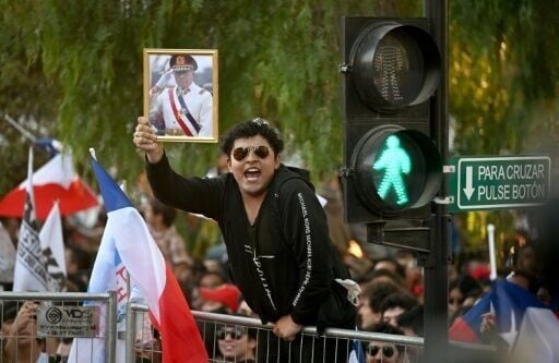 A man waves a portrait of the late Chilean dictator Augusto Pinochet in Santiago, decades after the deposed leader was accused of human rights violations