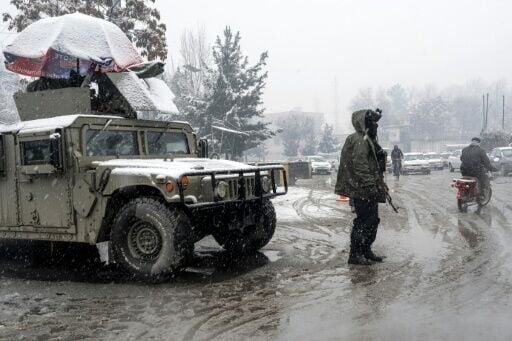 A Taliban security personnel stands guard at a checkpoint during snowfall in Kabul on January 22, 2026.