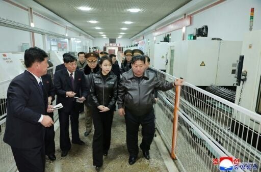 North Korean leader Kim Jong Un (R) and his daughter Kim Ju Ae (2nd R) inspecting the production of a new type of handgun
