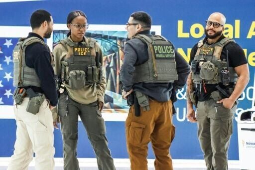Federal law enforcement agents, including some with US Immigration and Customs Enforcement (ICE), stand inside Newark Liberty International Airport in Newark, New Jersey
