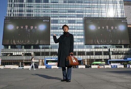 Sung Young-rok, a fan of K-pop boy group BTS, poses in front of billboards promoting a comeback concert of K-pop boy group BTS.