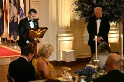 Defense Secretary Pete Hegseth (L) conducts a prayer as US President Donald Trump (R) listens during a dinner with state governors in the East Room of the White House in Washington, DC, on February 21, 2026.