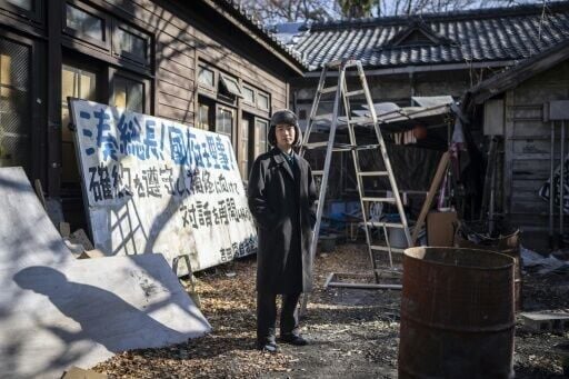 A signboard outside the Yoshida Dormitory reads: 'President Minami! Director Kokubu! Please honour your commitment and resume dialogue toward repairing the dormitory!'