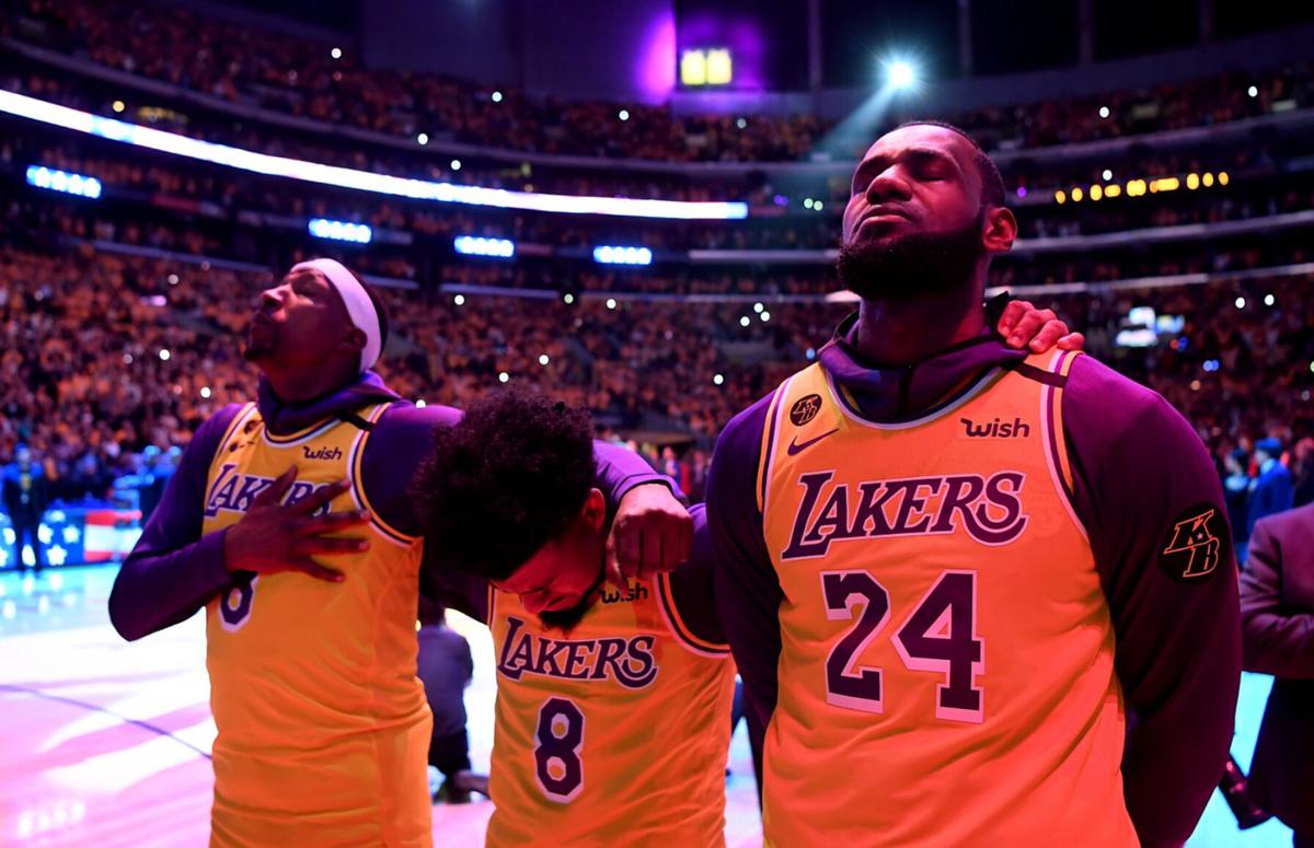 From left, the Los Angeles Lakers' Kentavious Caldwell-Pope, Quinn Cook, and LeBron James close their eyes during a tribute to Kobe Bryant on January 31, 2020, at Staples Center in Los Angeles.