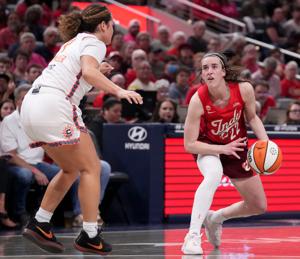 Connecticut Sun guard Charlisse Leger-Walker (4) defends Indiana Fever guard Caitlin Clark (22) as she looks to shoot during a