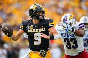 Sep 6, 2025; Columbia, Missouri, USA; Missouri Tigers quarterback Beau Pribula (9) rolls out to pass against Kansas Jayhawks defensive end Leroy Harris III (33) during the first half at Faurot Field at Memorial Stadium. Mandatory Credit: Jay Biggerst
