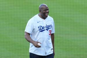 Los Angeles Dodgers minority owner Magic Johnson reacts before throwing the ceremonial first pitch before game five of the 2025 MLB World Series between the Toronto Blue Jays and the Los Angeles Dodgers at Dodger Stadium on Oct. 29, 2025, in Los Ange