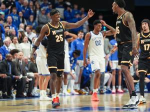 Missouri Tigers center Shawn Phillips Jr. (15) and Missouri Tigers forward Mark Mitchell (25) celebrate their team's first win at Rupp as a dismayed Kentucky Wildcats guard Otega Oweh (00) is in the background as the Cats fell to the Tigers 73-68 dur