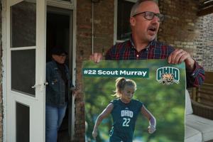 David Murray unfurls a poster of his daughter, Scout, in soccer competition Thursday, April 9, 2026, in Chicago.