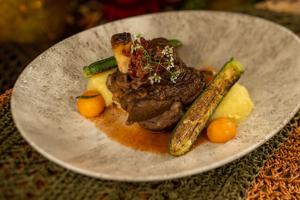 The Moroccan-spiced Lamb Shank at Jiko- The Cooking Place, a signature entree served with couscous, preserved lemon, olives, Marcona almonds and lamb demi-glace.