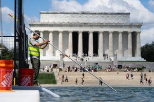Crews clean up algae that began to grow in the Reflecting Pool days after the Trump administration’s at least $13 million