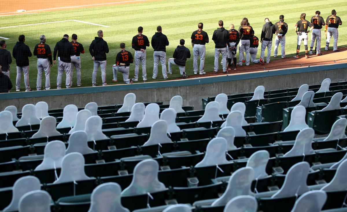 Austin Slater #13 and Jaylin Davis #49 of the San Francisco Giants kneel during the National Anthem before their exhibition game against the Oakland Athletics at Oakland-Alameda County Coliseum on July 20, 2020 in Oakland, California.