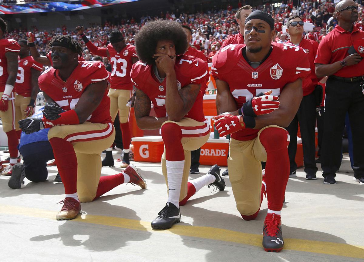 Eli Harold (58), Colin Kaepernick (7) and Eric Reid (35) of the San Franciso 49ers kneel during the national anthem before a game against the Dallas Cowbowy on October 2, 2016, at Levi's Stadium, in Santa Clara, Calif.