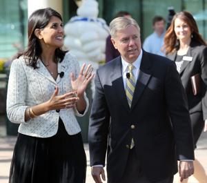 South Carolina Governor Nikki Haley and U.S. Senator Lindsey Graham walk together outside of the Michelin headquarters in