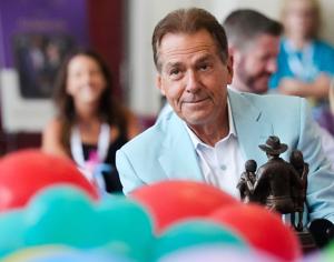 Aug. 4, 2026; Tuscaloosa, AL, USA;  Nick Saban smiles as hold the Lifetime Achievement Award he and Terry Saban are about to present to Stephanie Bryan, Chair and CEO of the Poarch Band of Creek Indians, at the North Zone in Bryant-Denny Stadium for 