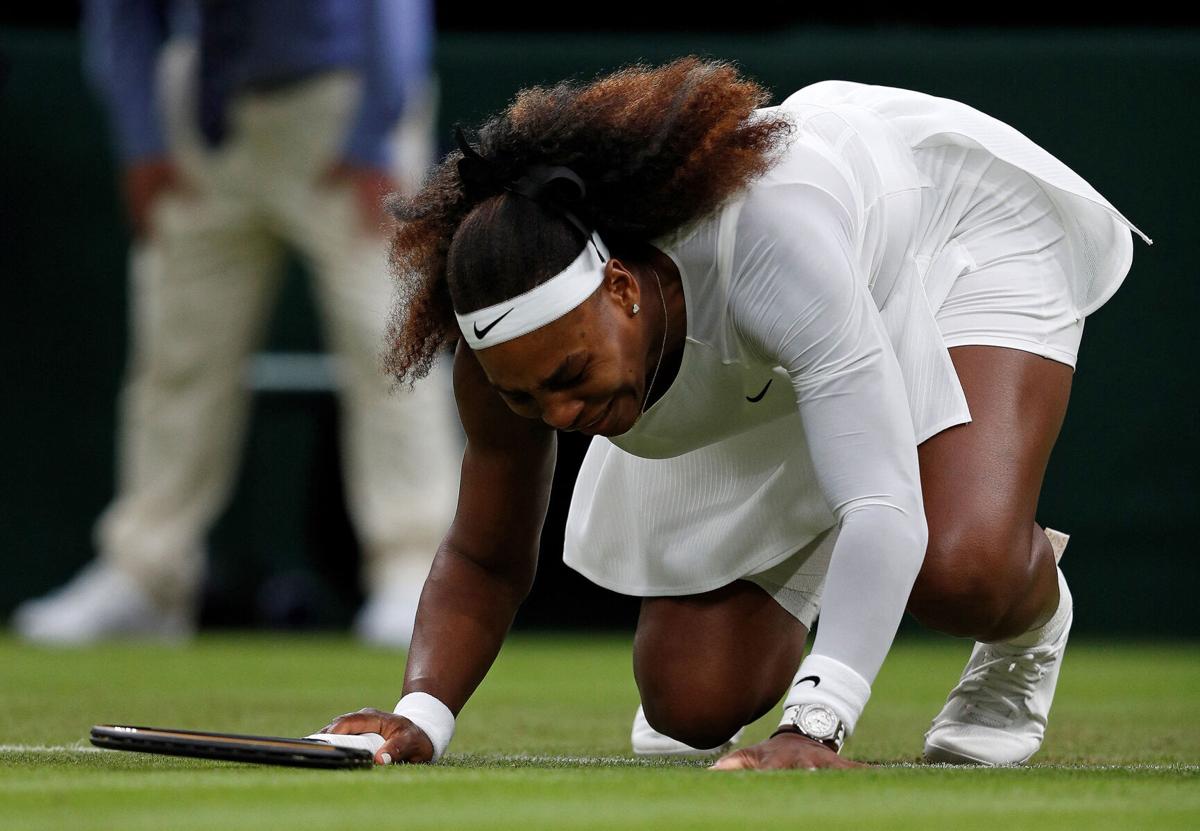 A leg injury brings Serena Williams to her knees before withdrawing from her women's singles first-round match against Belarus's Aliaksandra Sasnovich on the second day of the Wimbledon Championships at The All England Tennis Club in London, on Tuesday, June 29, 2021.