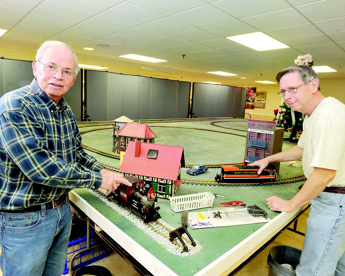 Ron Reinbold left and Win Garland model train enthusiasts work on the Christmas Town Railroad Display at Arbutus Park Retirement munity in Richland