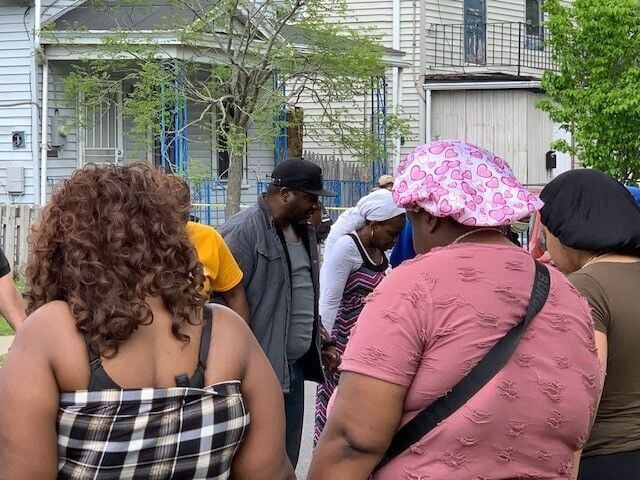 Pastor Tim Newkirk leads a prayer circle with survivors of the Tops massacre on Riley Street, just outside the store on May 14