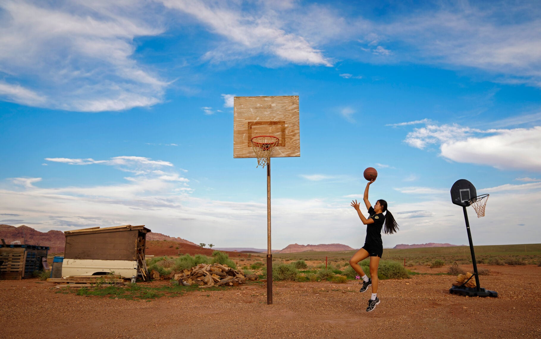 Layla Curtis shoots as she practices at her home in The Gap on the Navajo reservation near Tuba City, Arizona, on Aug. 12, 2026. The hoop is the same one her father shot on as a Tuba City basketball star.