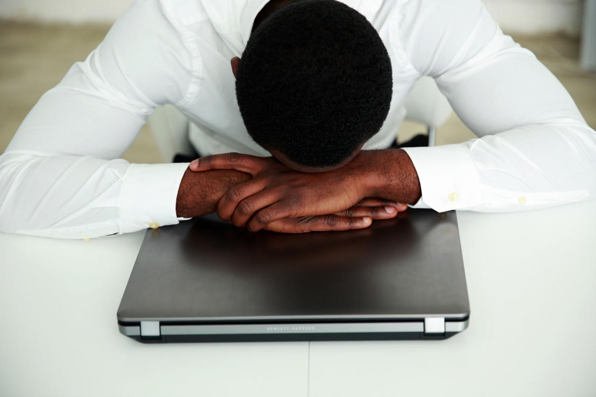 African man sleeping at his workplace in office