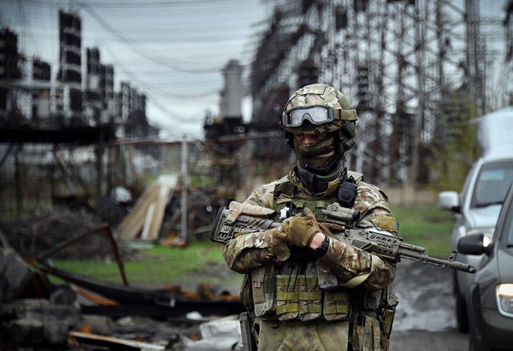 In this picture taken on April 13, 2022, a Russian soldier stands guard at the Luhansk power plant in the town of Shchastya.