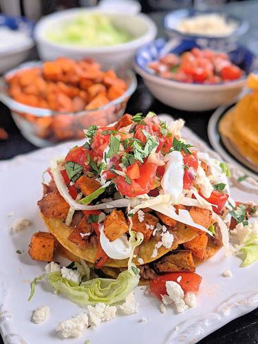 These vegetarian tostadas are stacked with two layers of smashed pinto beans, lettuce, pico and roasted sweet potatoes and bell peppers.