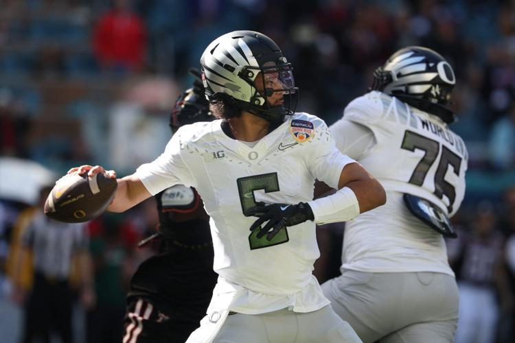 Jan 1, 2026; Miami Gardens, FL, USA; Oregon Ducks quarterback Dante Moore (5) looks to pass the ball against the Texas Tech Red Raiders during the first half of the 2025 Orange Bowl and quarterfinal game of the College Football Playoff at Hard Rock Stadium
