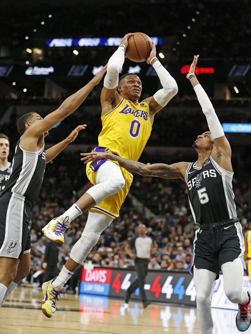 Russell Westbrook #0 of the Los Angeles Lakers jumps to the basket past Dejounte Murray #5 of the San Antonio Spurs in the first half at AT&T Center on March 7, 2022, in San Antonio, Texas.