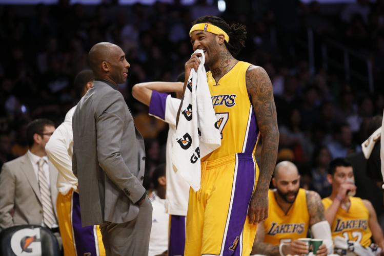Kobe Bryant, who is injured, laughs with Los Angeles Lakers' Jordan Hill during a stop in play