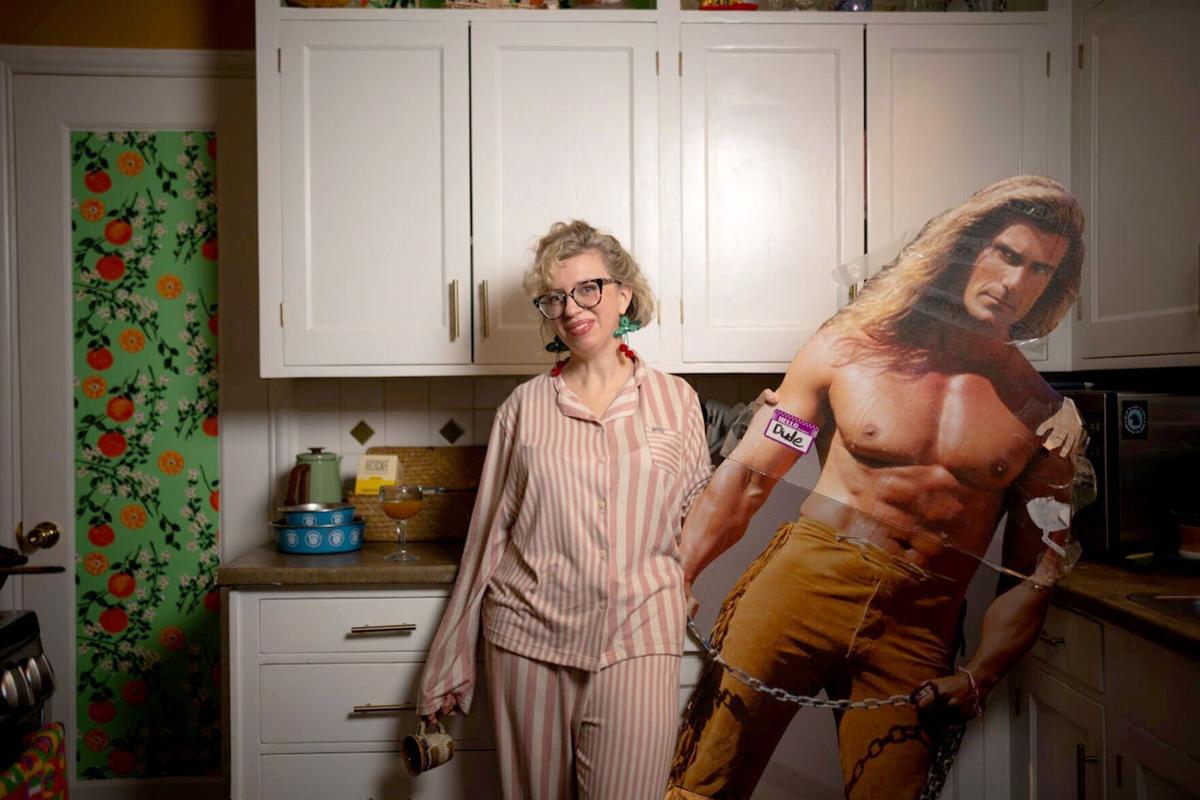 Romance writer Sam Tschida, with a cardboard cutout of Fabio in the kitchen of her St. Paul home, is a former lawyer who writes romance/mysteries and runs an online class for writers called Smut U. Her book "Errands and Espionage" is being made into a movie.